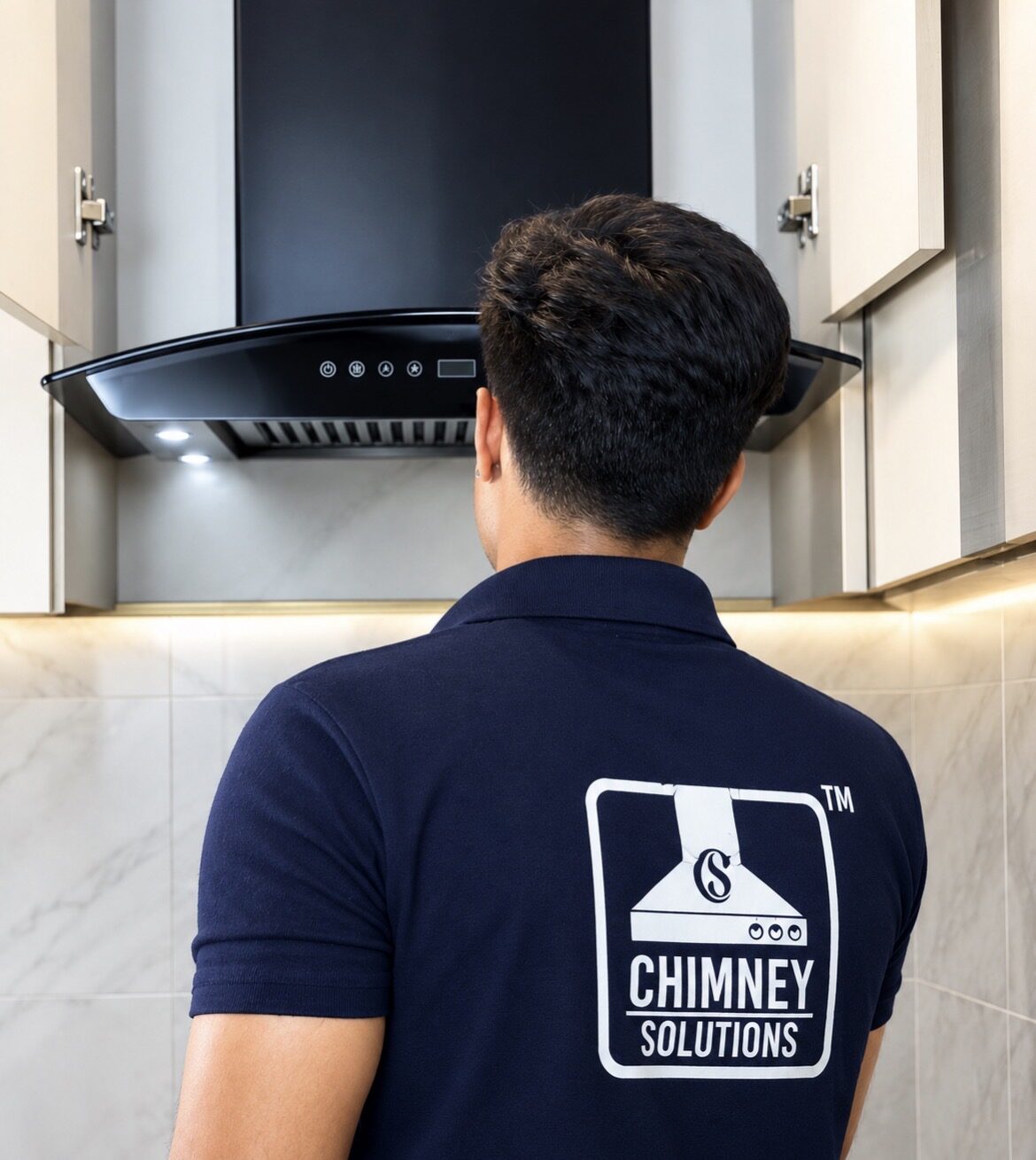 Chimney Solutions technician inspecting an installed kitchen chimney